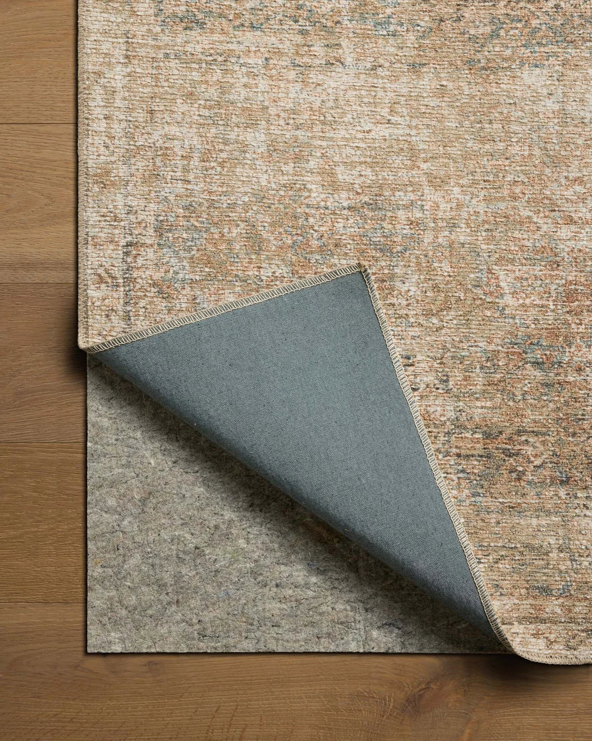 Close-up of the Cambria rug highlighting the woven jute texture and subtle Ocean blue and Brick color palette.