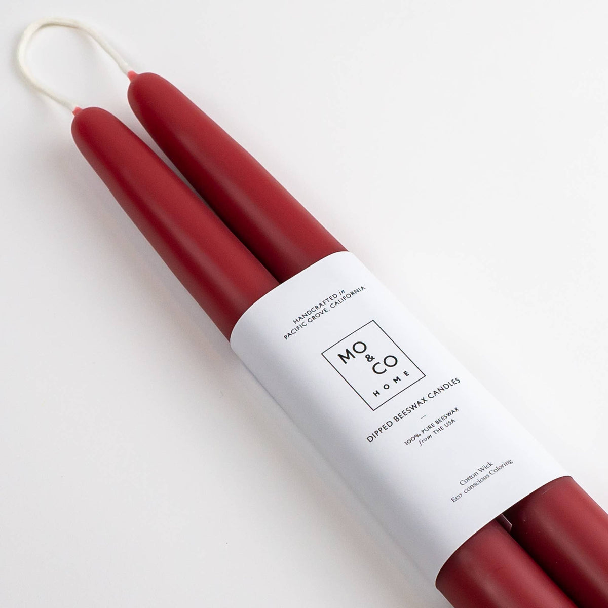 Pair of berry red beeswax taper candles with a classic slender silhouette and handcrafted finish.