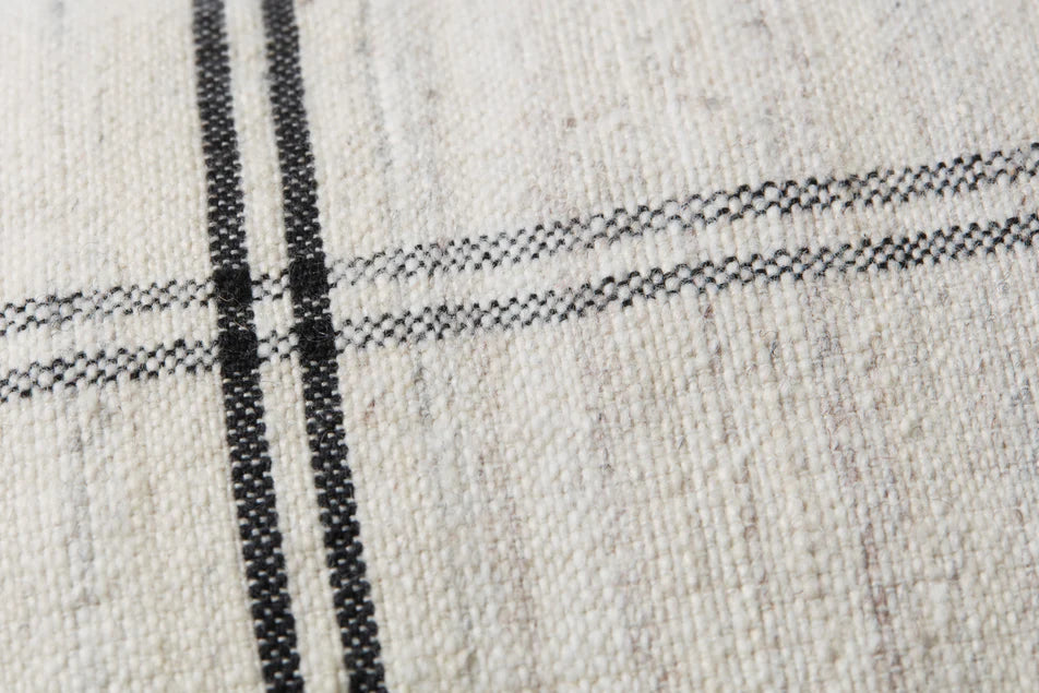 Close-up of the handwoven texture on the Amber Lewis Bell pillow.