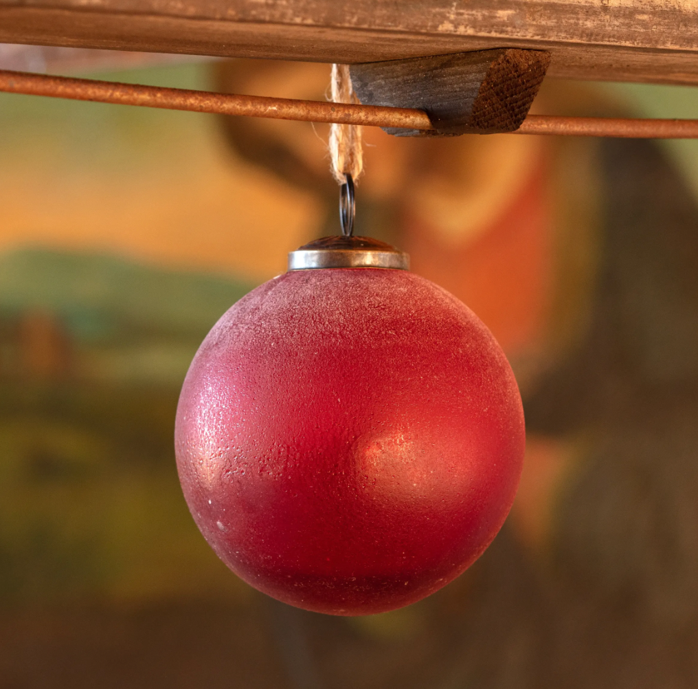 Frosted ruby red glass ball ornament with a rich, deep red finish, measuring 4 inches in diameter.