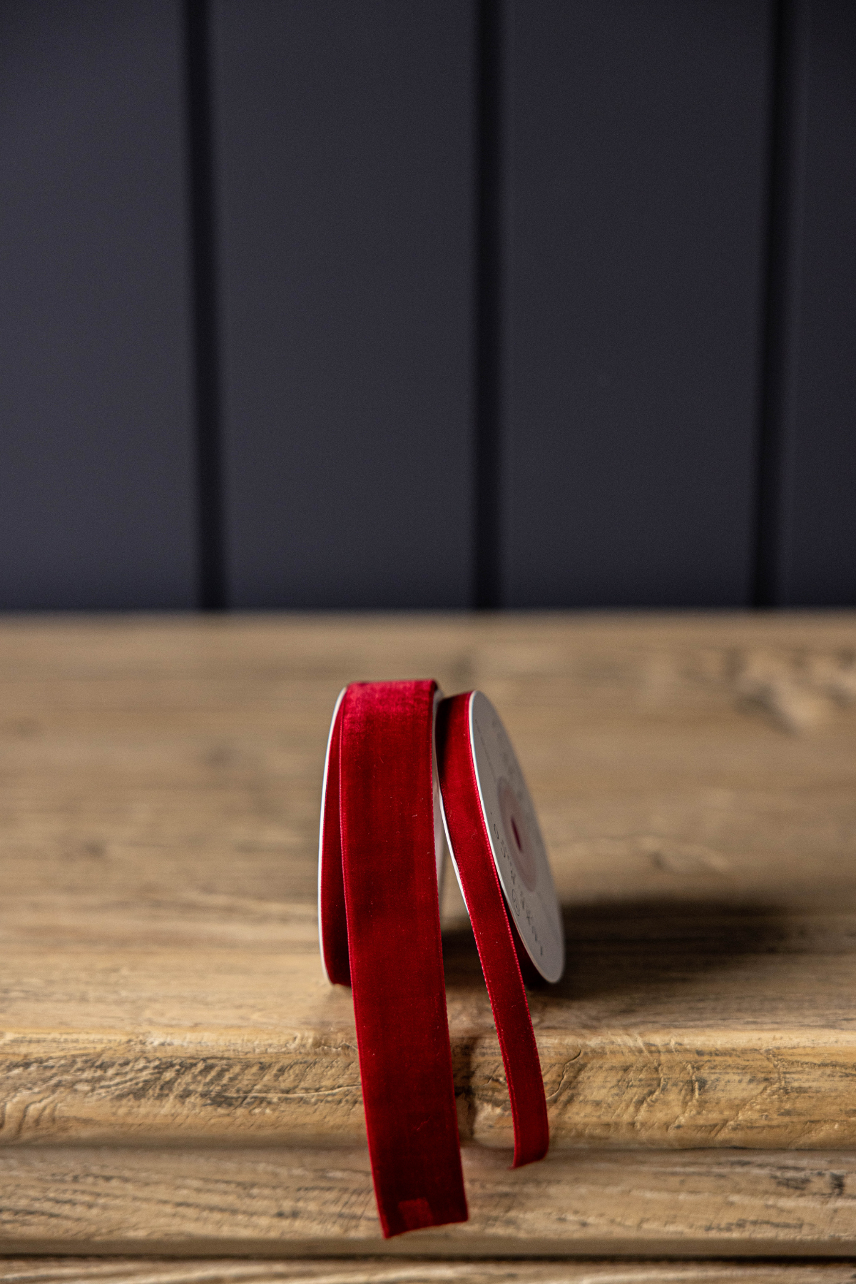 Spool of garnet red velvet holiday ribbon measuring 1 inch wide and 5 yards long.