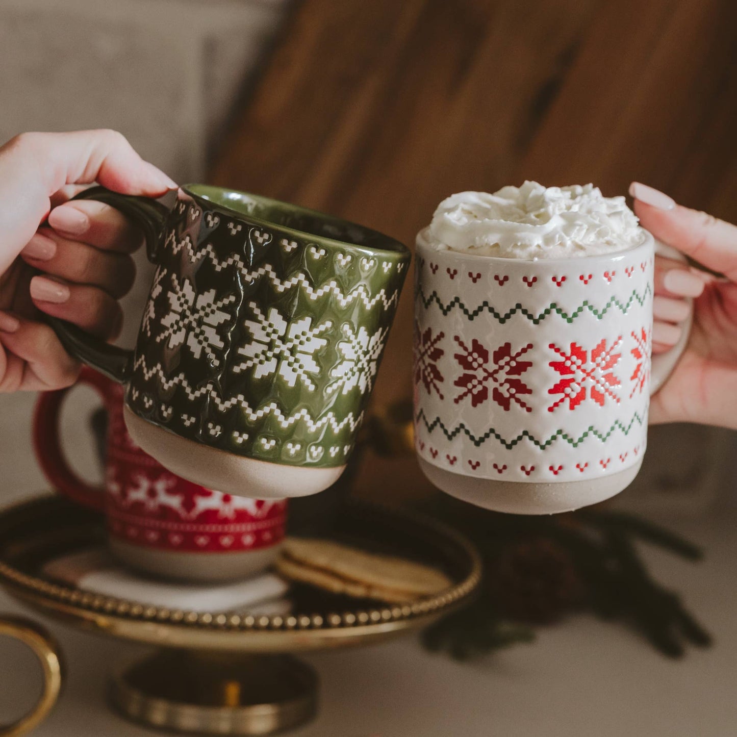 Cream stoneware coffee mug with an embossed red and green Fair Isle sweater pattern wrapping around the mug.