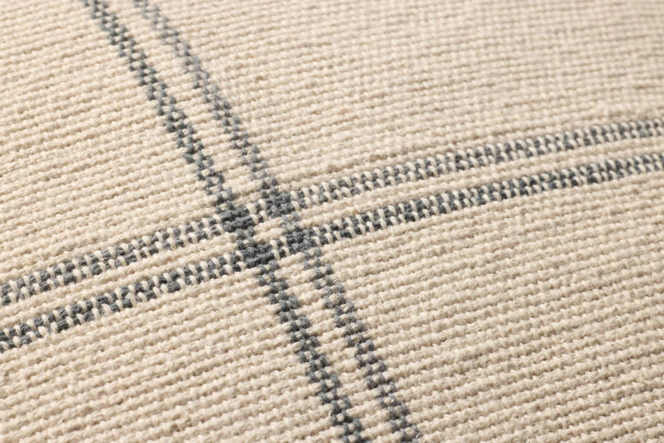 Close-up of the handwoven cotton texture and fringe edge on the Amber Lewis Lainey pillow.