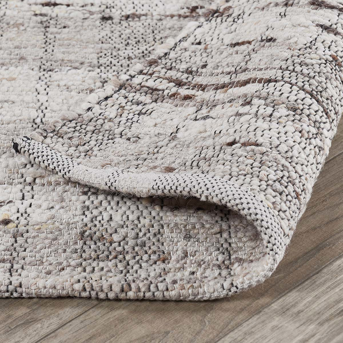 Close-up of the Perth rug showcasing the lofty hand-carded wool, subtle plaid detailing, and artisan handwoven craftsmanship.