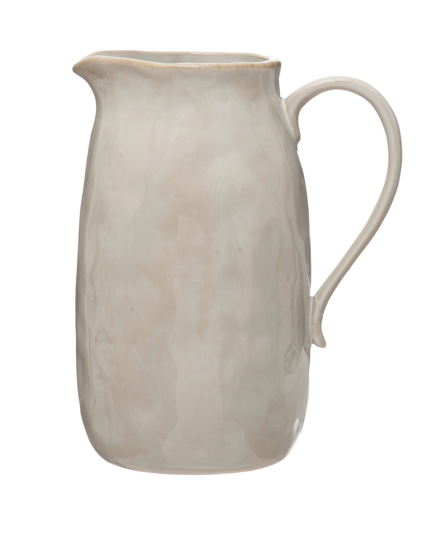 White reactive glaze stoneware pitcher with artisan-crafted texture and timeless silhouette.