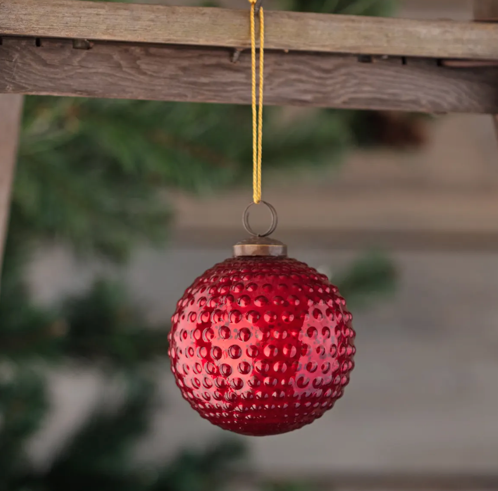 Ruby red mercury glass Christmas ornament with vintage-inspired hobnail texture, measuring 4 inches in diameter.
