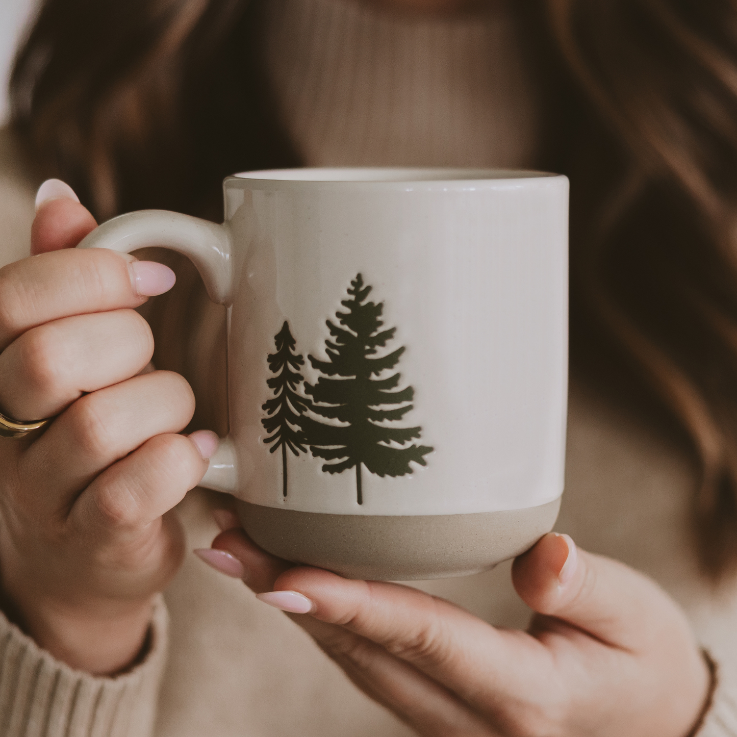 Artisan-inspired cream stoneware mug with green tree illustrations, perfect for cozy mornings or gifting to nature lovers.
