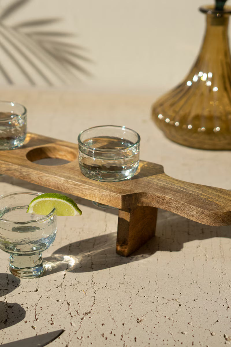 Wooden tasting flight board with individual glass holders.