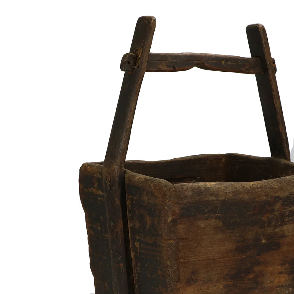 Close-up of the weathered wood, original handle, and rich patina of a vintage grain box.