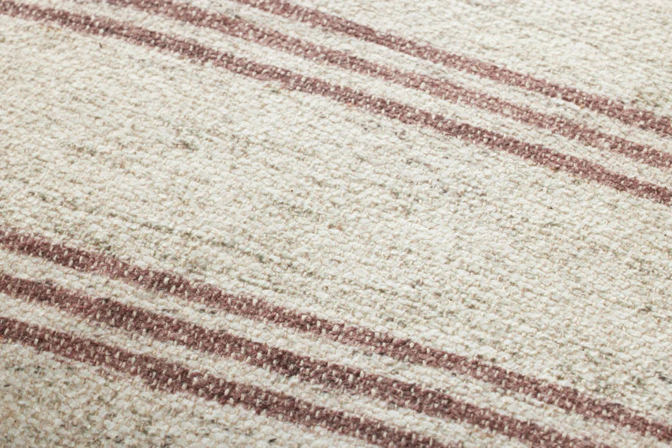 Close-up of the woven polyester and cotton fabric with rich wine accents on the Amber Lewis Zephyr pillow.