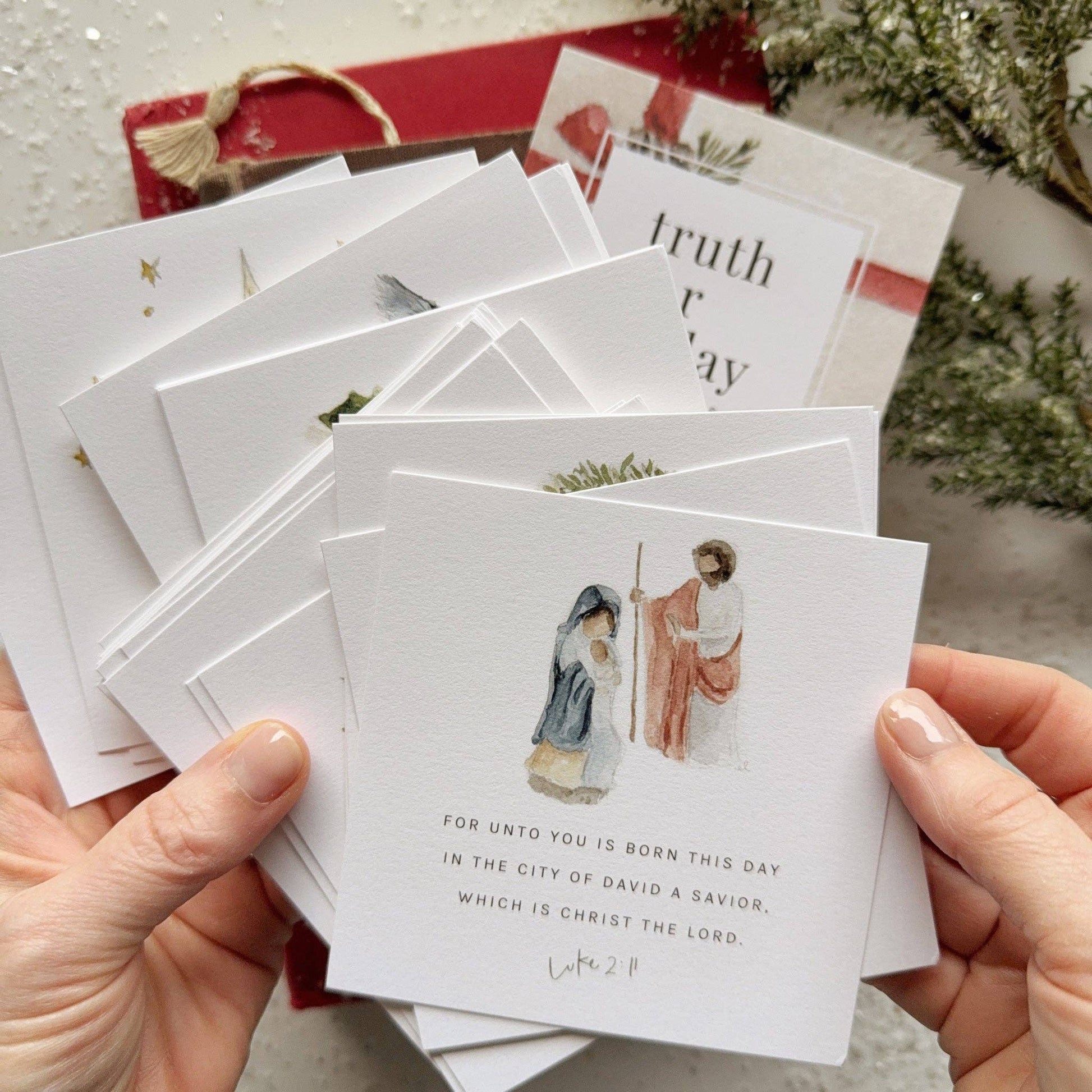 Close-up of Christmas Scripture cards printed on premium 120 lb cotton eggshell textured paper with original watercolor artwork and encouraging Bible verses.
