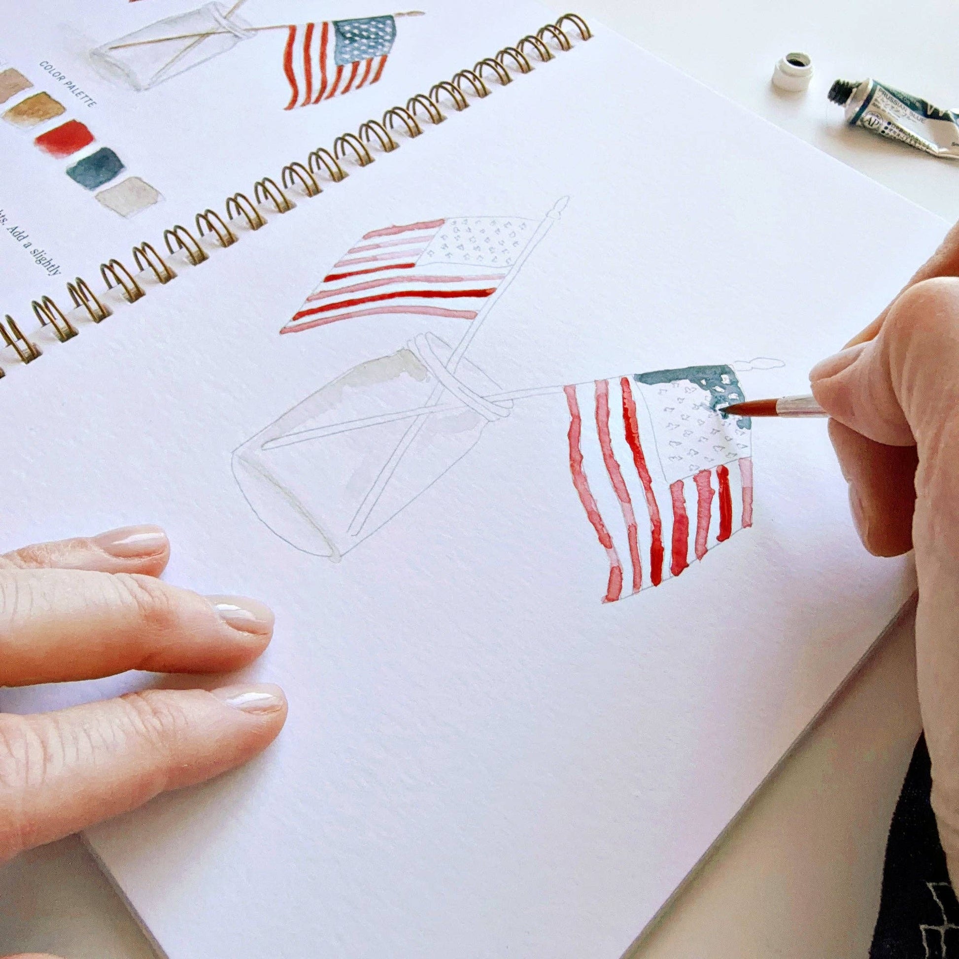 Step-by-step watercolor workbook with pre-outlined Americana illustrations ready to paint.