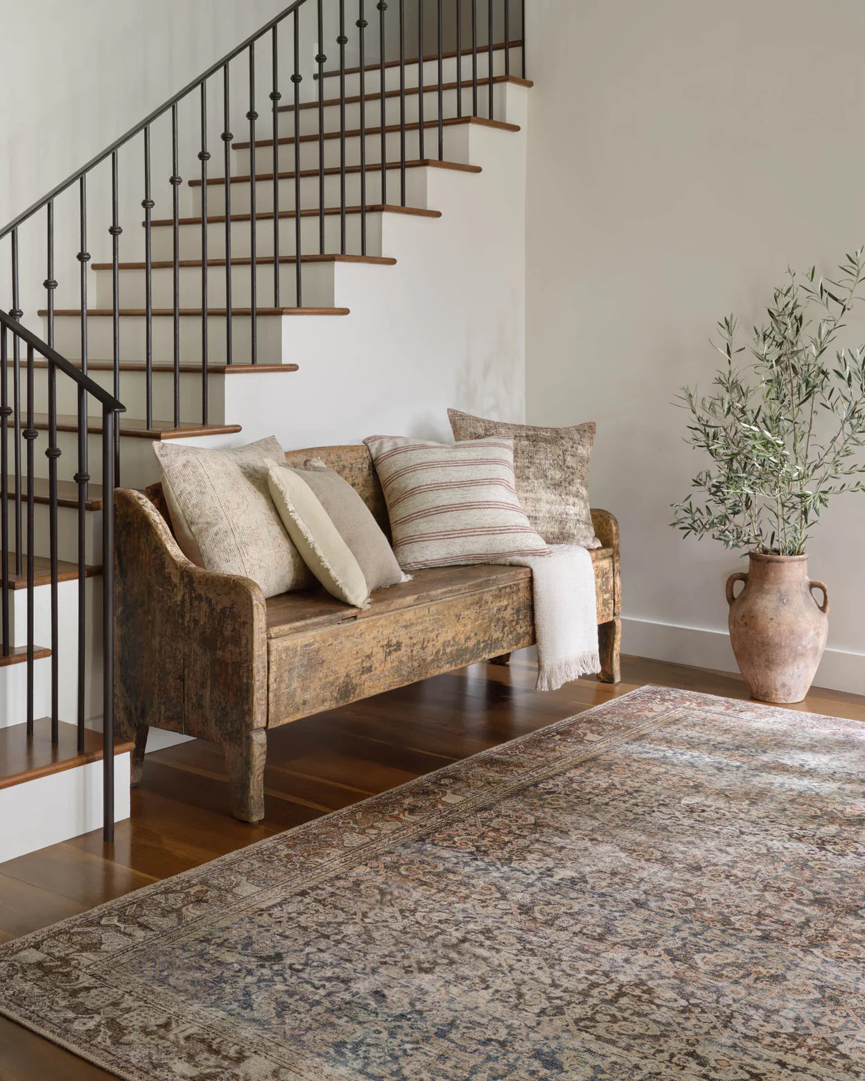 Amber Lewis Celestia throw pillow layered on a neutral sofa with warm wood accents.