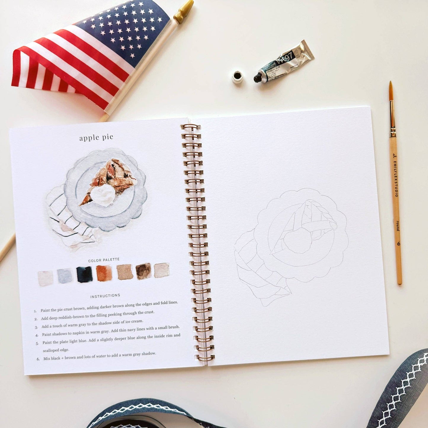 Americana watercolor workbook styled with paint supplies for a creative summer afternoon.