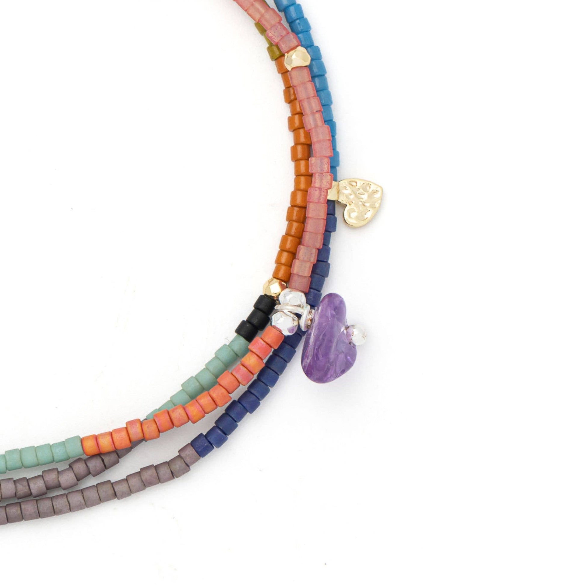 Close-up of handcrafted amethyst stones, freshwater pearls, Miyuki beads, and the adjustable pull-tie on the Mixed Media Wrap Bracelet & Necklace.