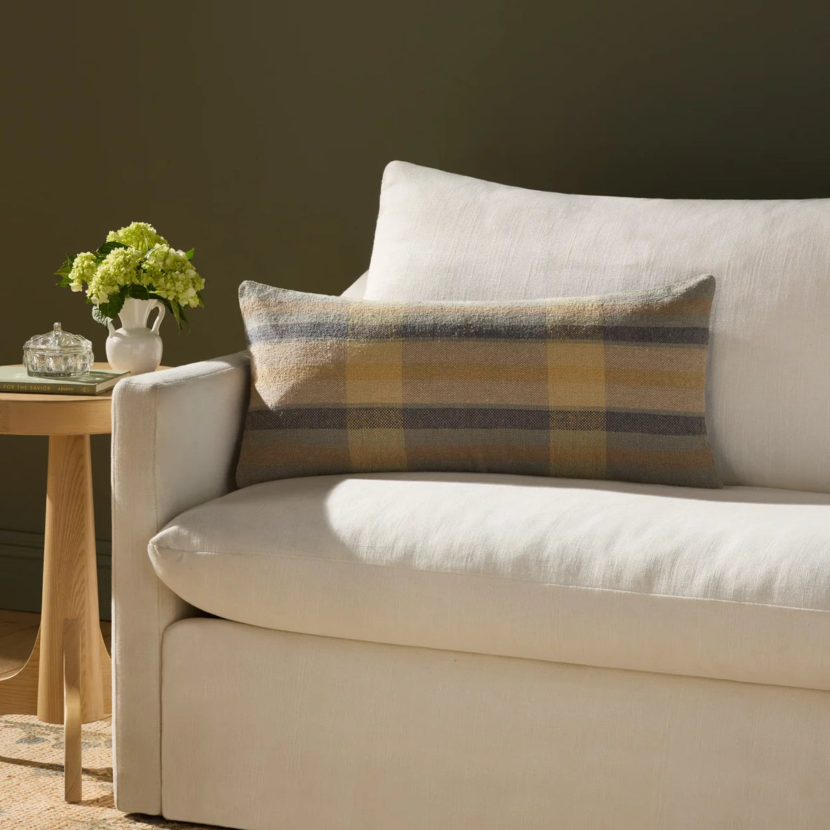 Andi Yellow and Blue throw pillow styled on a linen sofa with neutral pillows, a woven throw, and natural wood accents in an organic modern living room.