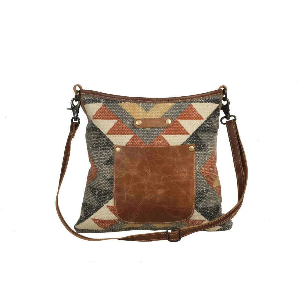 Angle Tangle shoulder bag crafted from patterned woven rug textile, canvas, and genuine leather.
