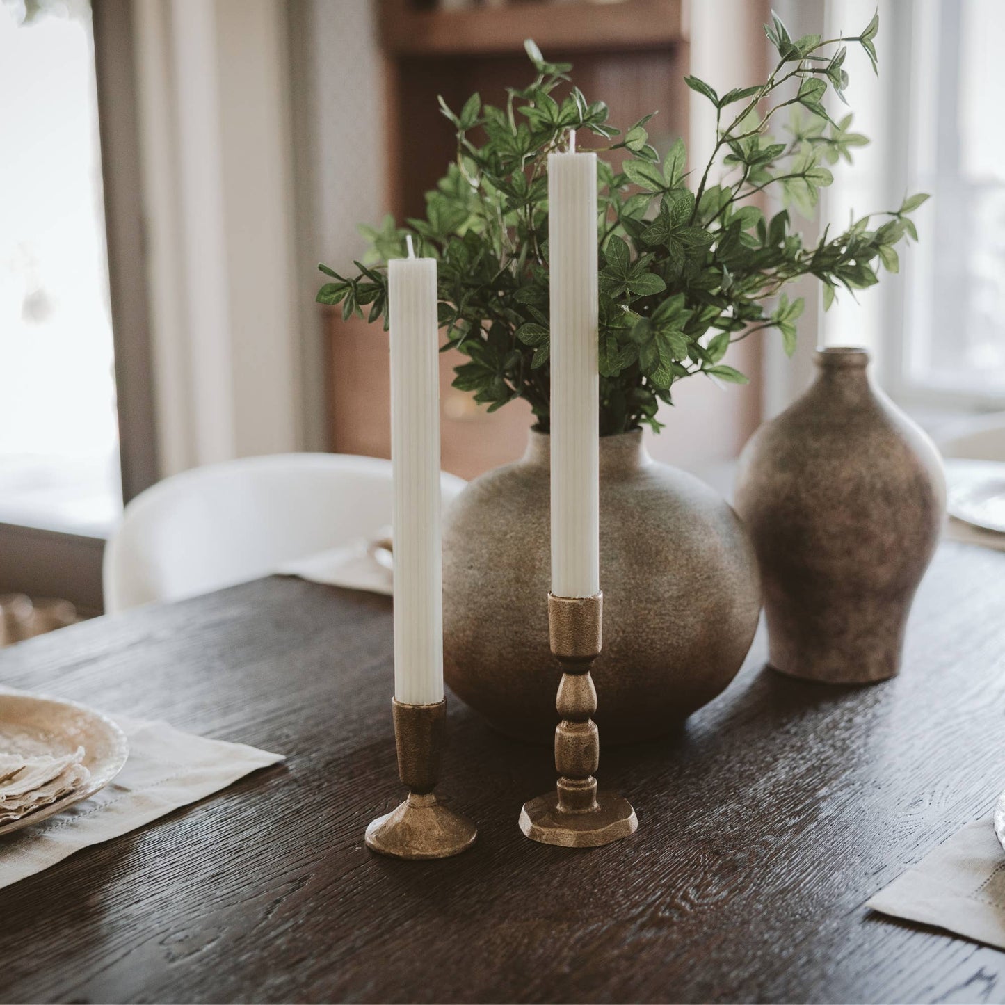Set of two antique gold cast iron taper candle holders with a timeless candlestick silhouette.