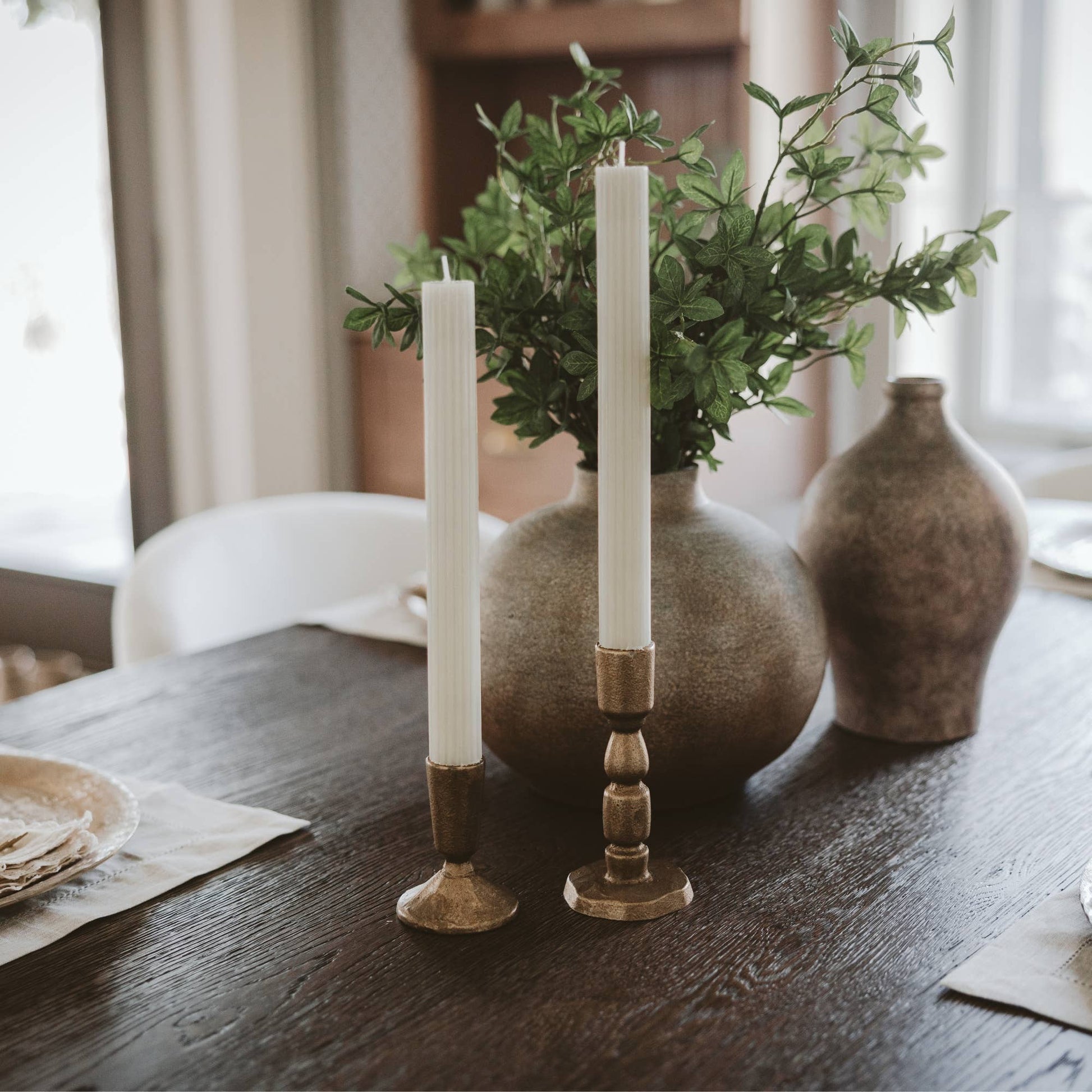 Set of two antique gold cast iron taper candle holders with a timeless candlestick silhouette.
