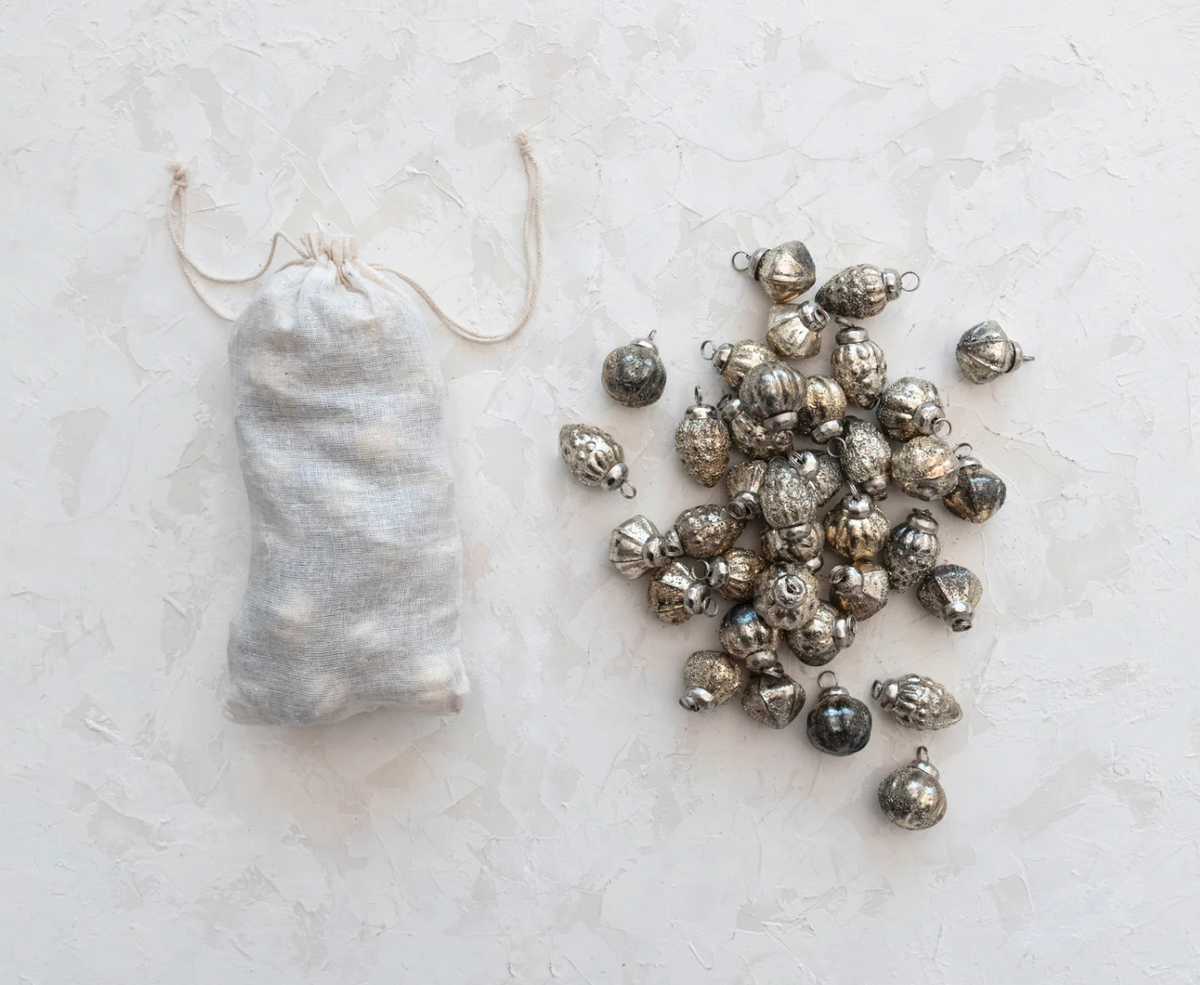 Miniature embossed glass Christmas ornaments with varied patterns and a softly aged antique silver mercury finish.