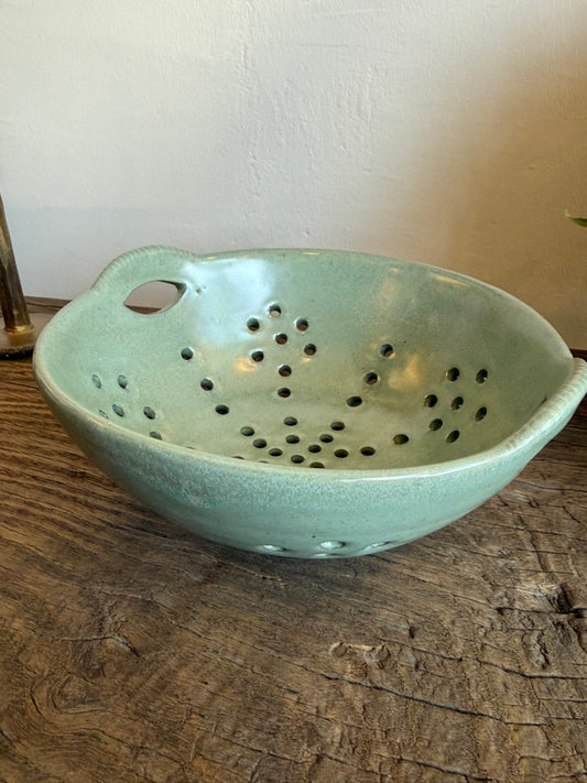 Aqua reactive glaze stoneware berry bowl with integrated handles and open basket-inspired design.