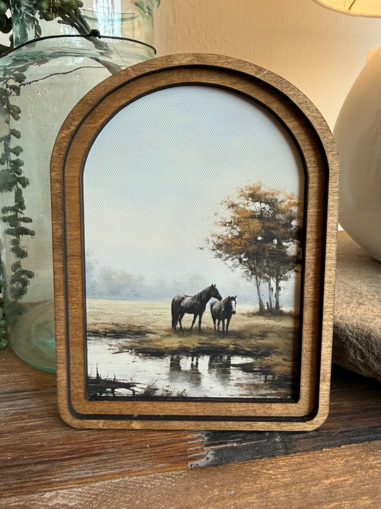 Arch Top Pasture Horses Framed Canvas Art featuring horses grazing in a peaceful pasture within a handcrafted arched wood frame finished in an Early American stain.