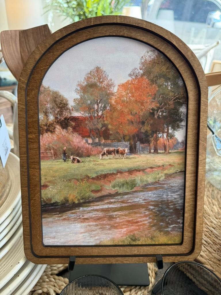 Arch Top Riverside Farm Framed Canvas Art featuring a peaceful countryside farm along a river in a handcrafted arched wood frame with an Early American finish.
