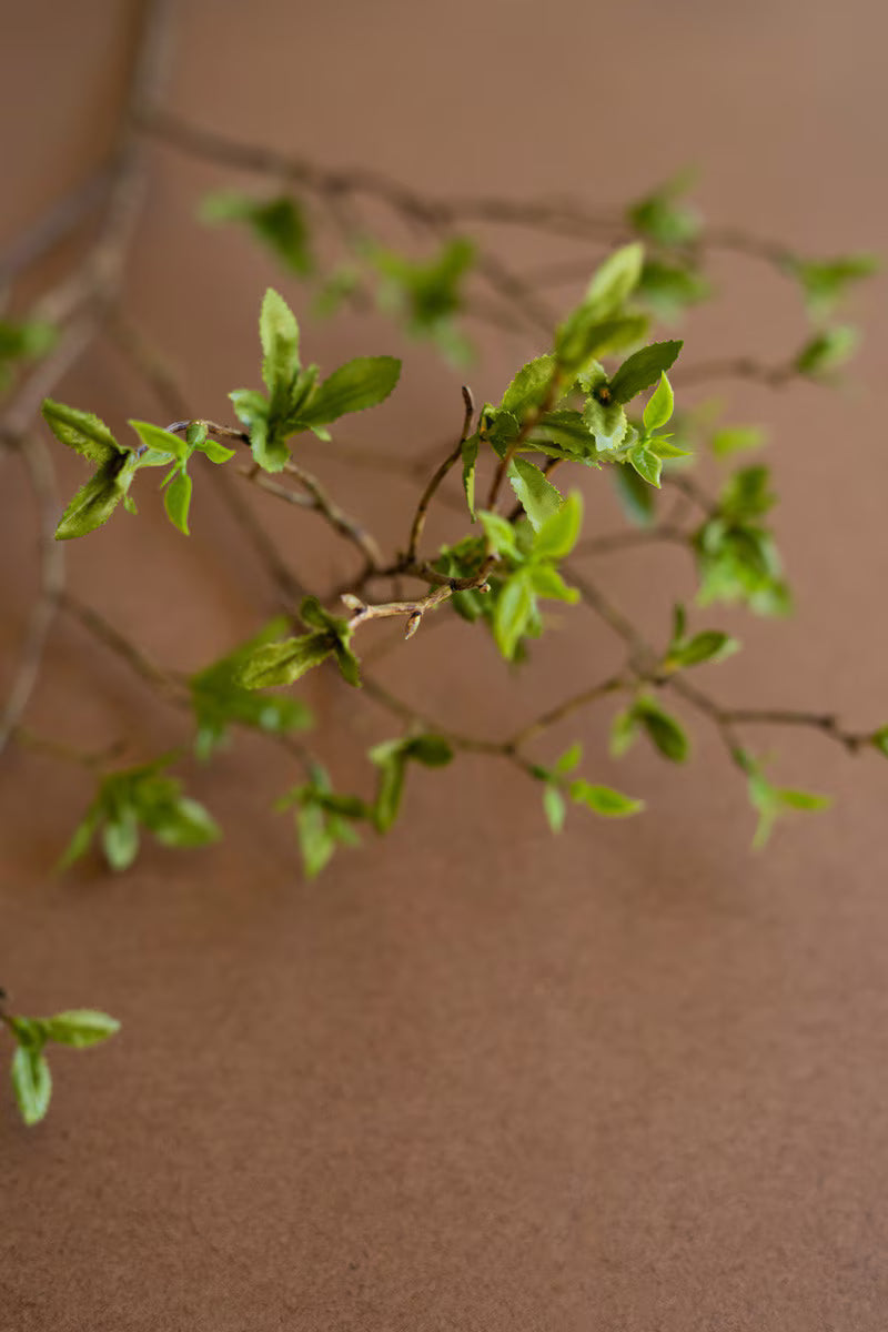 Close-up of the faux green berries and budding leaves showcasing lifelike botanical details.