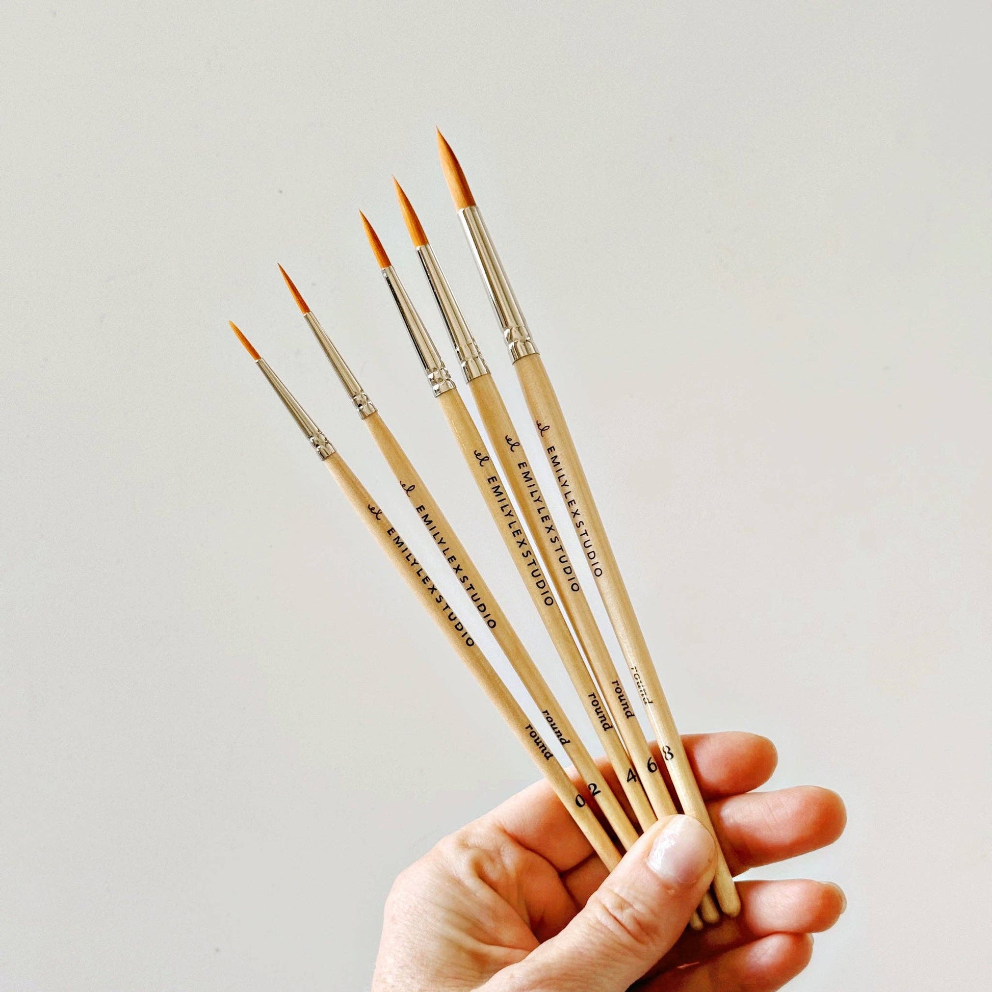 Watercolor paintbrush featuring a lacquered wood handle and fine synthetic bristles.