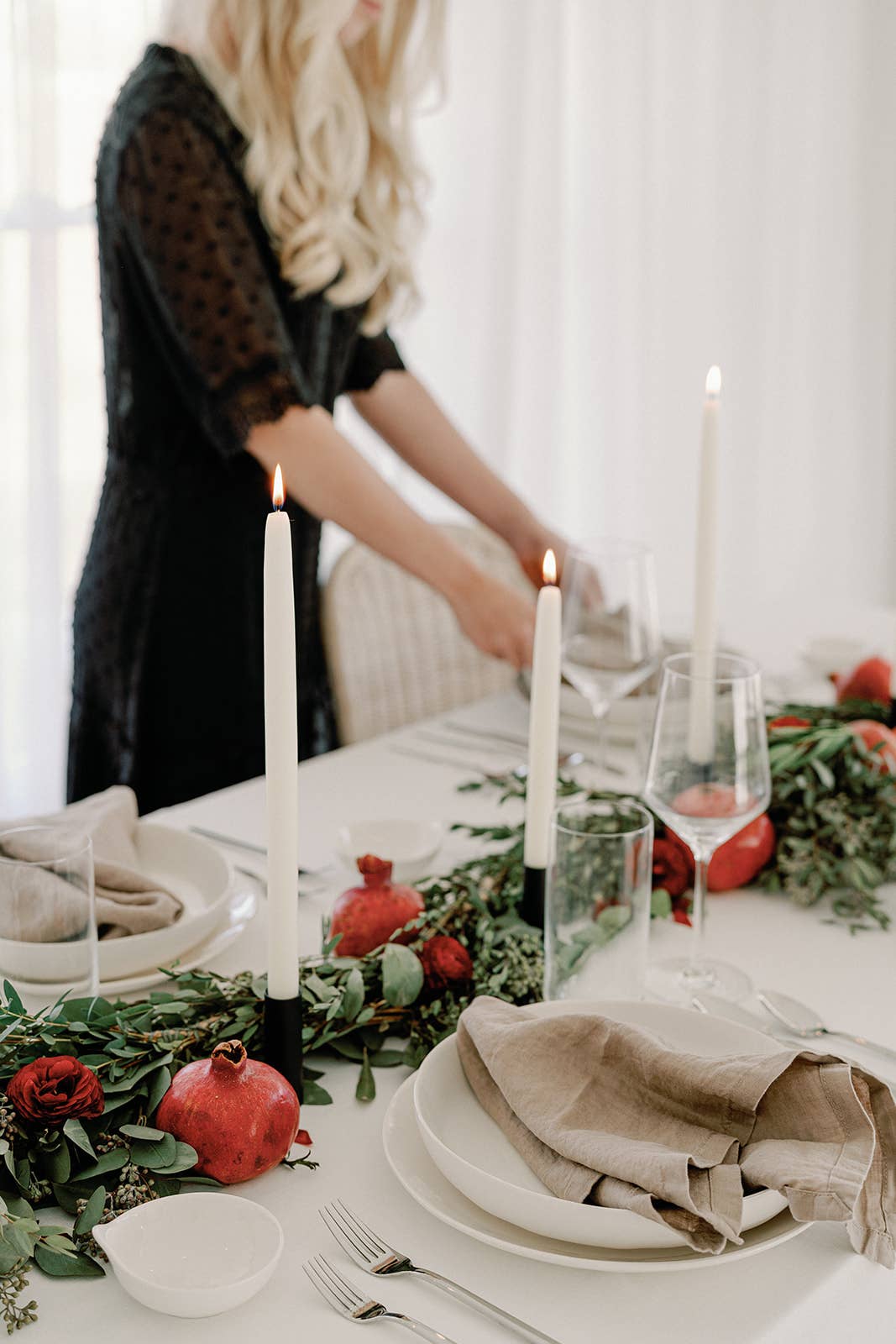 Hand-dipped beeswax taper candles styled in brass candlesticks on a collected dining table.