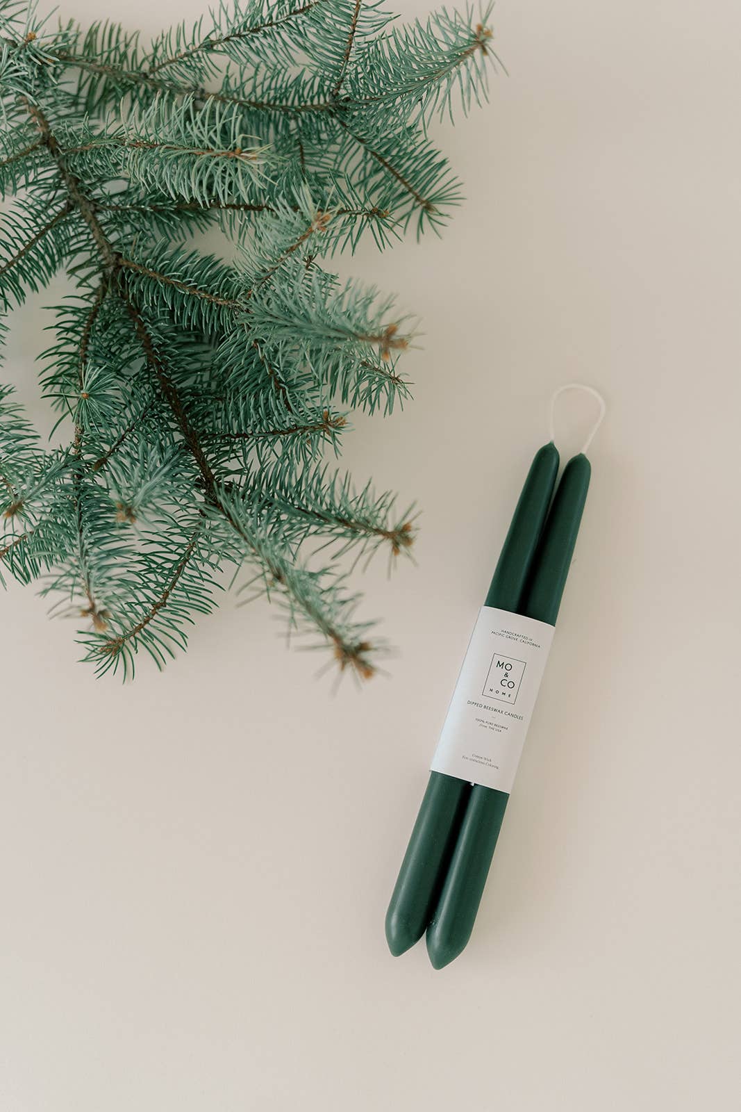 Pair of forest green hand-dipped beeswax taper candles measuring 10 inches tall.