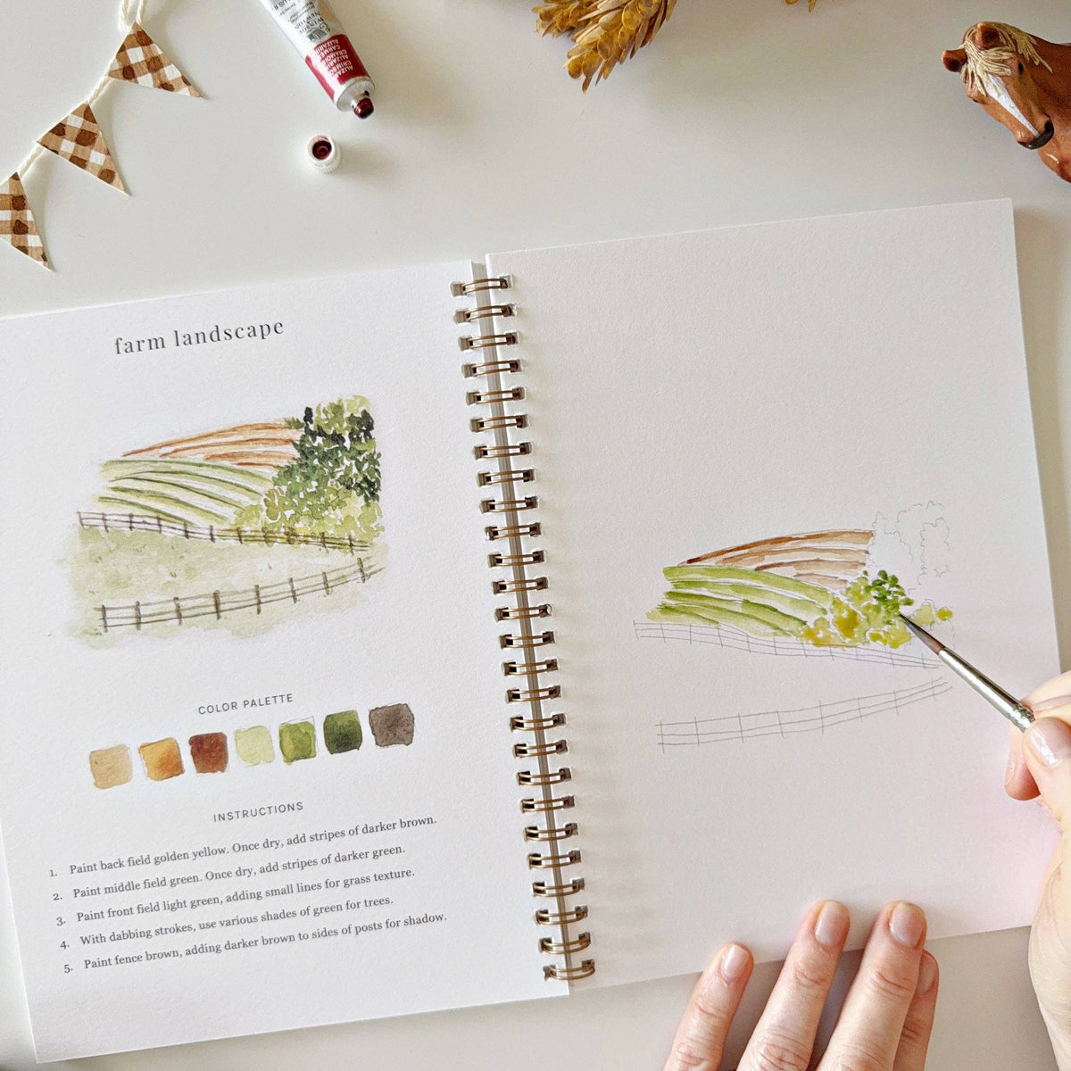 Farm Watercolor Workbook styled with watercolor paints, brushes, fresh wildflowers, and rustic farmhouse décor for a peaceful creative afternoon.