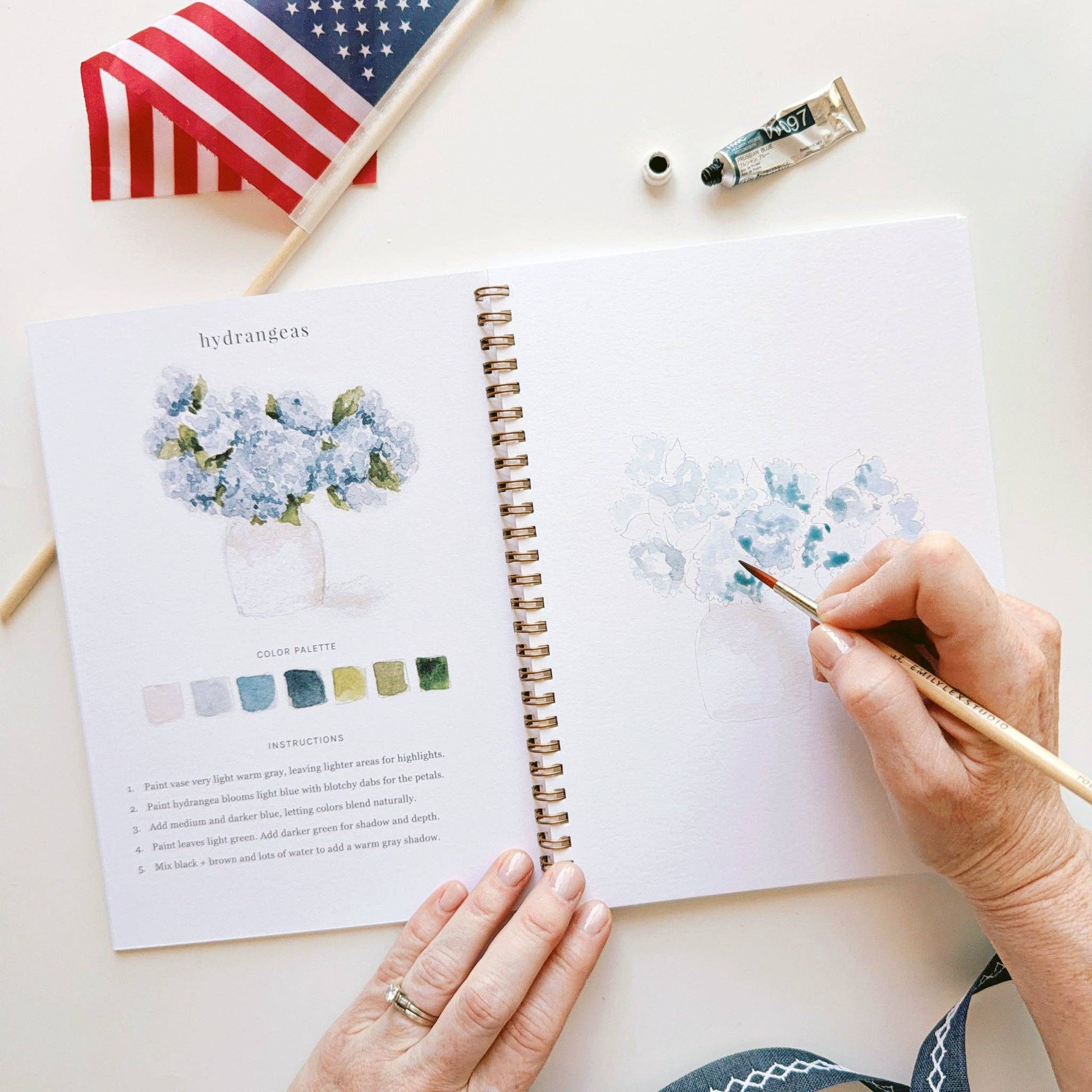 Beginner-friendly watercolor workbook featuring patriotic artwork and guided instruction.