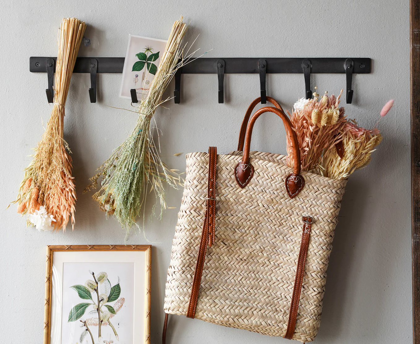 Black iron eight-hook coat rack mounted in an entryway for everyday storage.