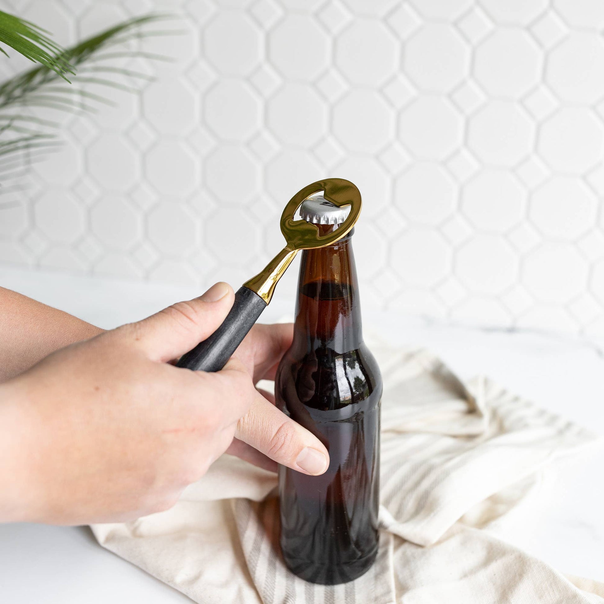 Louisa bottle opener featuring a genuine black marble handle and brass-finished metal.