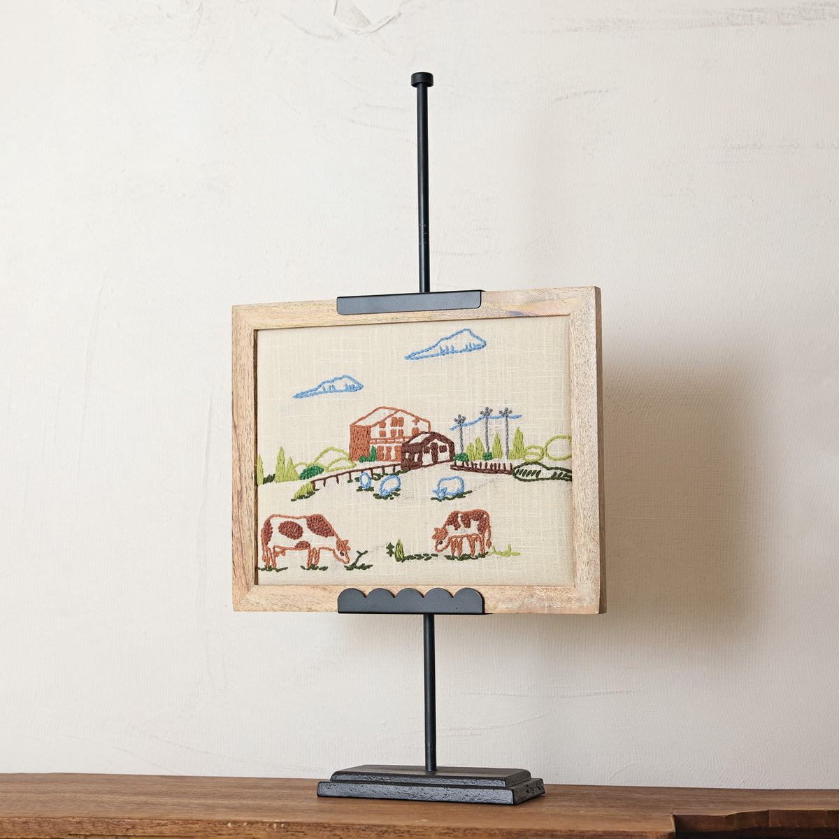 Black adjustable metal display easel with a slender silhouette and decorative scalloped detailing.