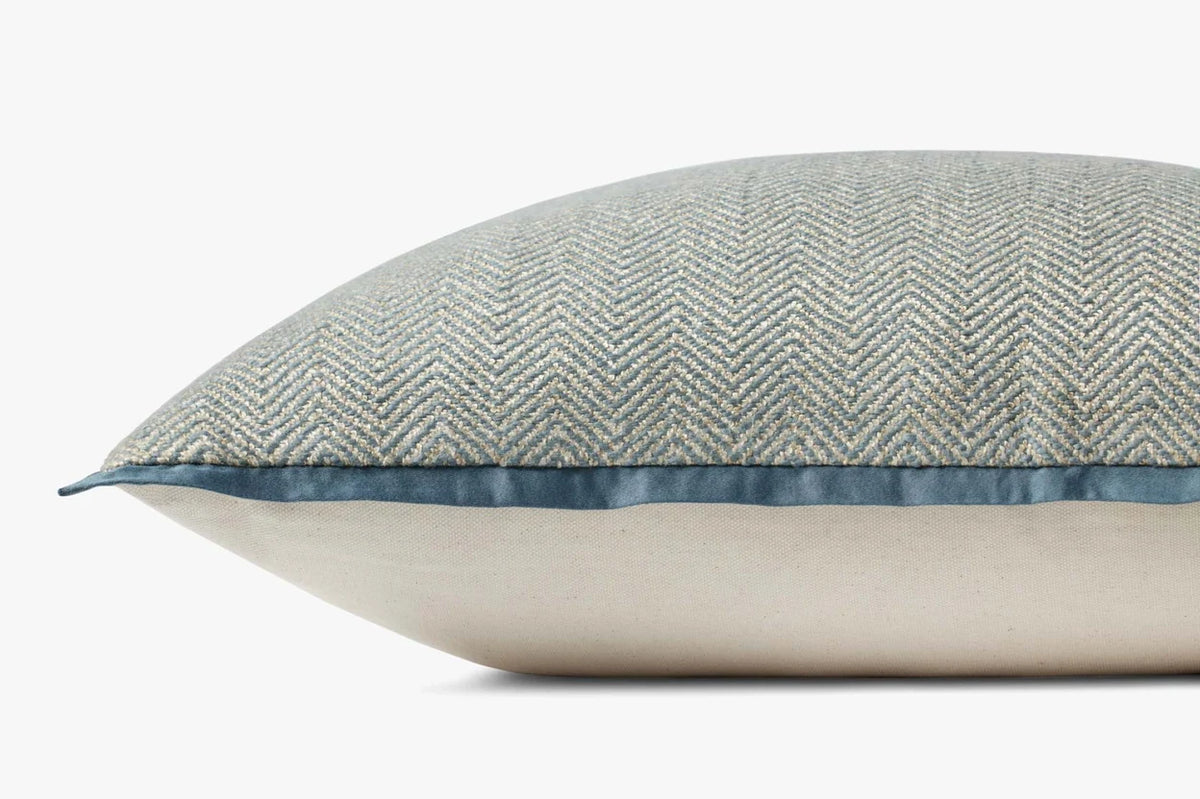 Close-up of the blue hand-stitched pillow highlighting the textured stitching, contrast flange, and hidden zipper with antique bronze Loloi logo pull.