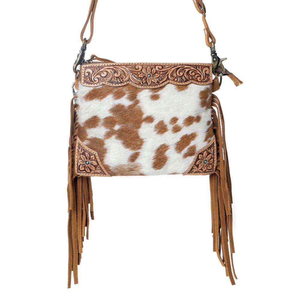 Bourbon Trail Handtooled Hairon Crossbody Bag featuring genuine leather, handtooled detailing, natural brown and white cowhide, and flowing Western fringe.
