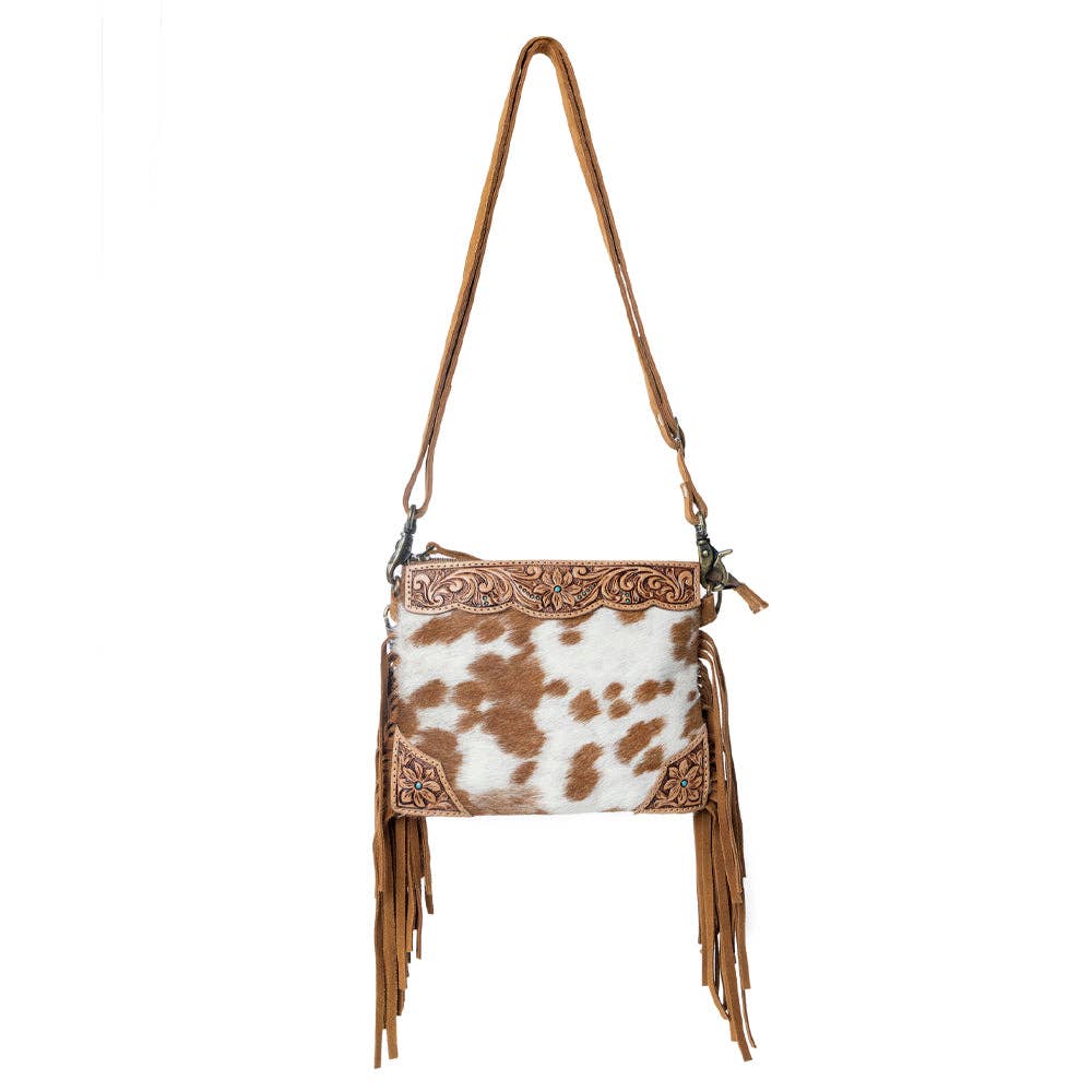 Bourbon Trail Handtooled Hairon Crossbody Bag featuring genuine leather, handtooled detailing, natural brown and white cowhide, and flowing Western fringe.