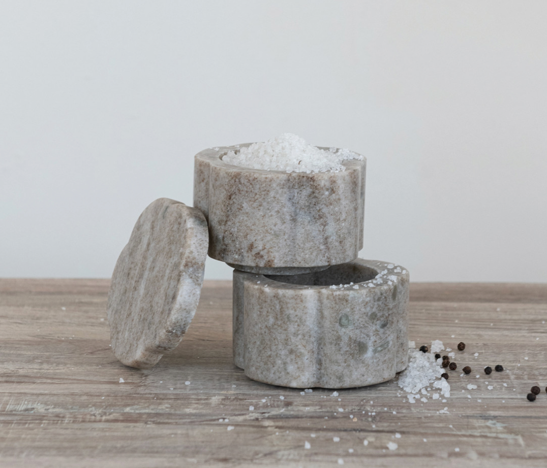 Set of two buff marble scalloped pinch pots with matching lids and natural stone variation.