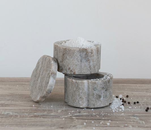 Set of two buff marble scalloped pinch pots with matching lids and natural stone variation.
