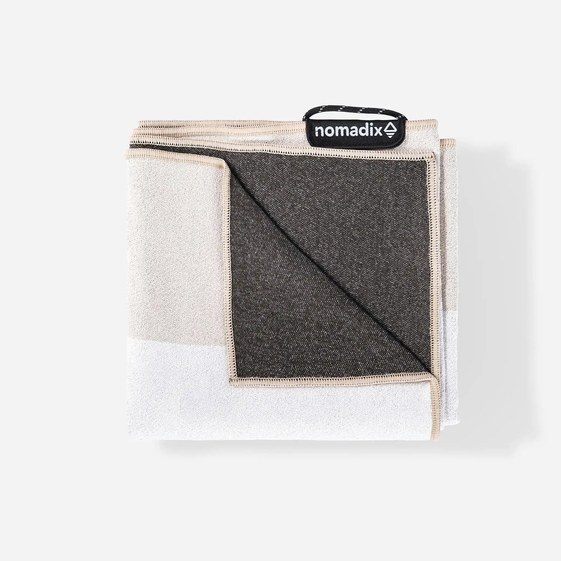 Close-up of the Classic Cabana Tan Nomadix towel highlighting the textured performance fabric, woven stripe pattern, and built-in hanging loop.