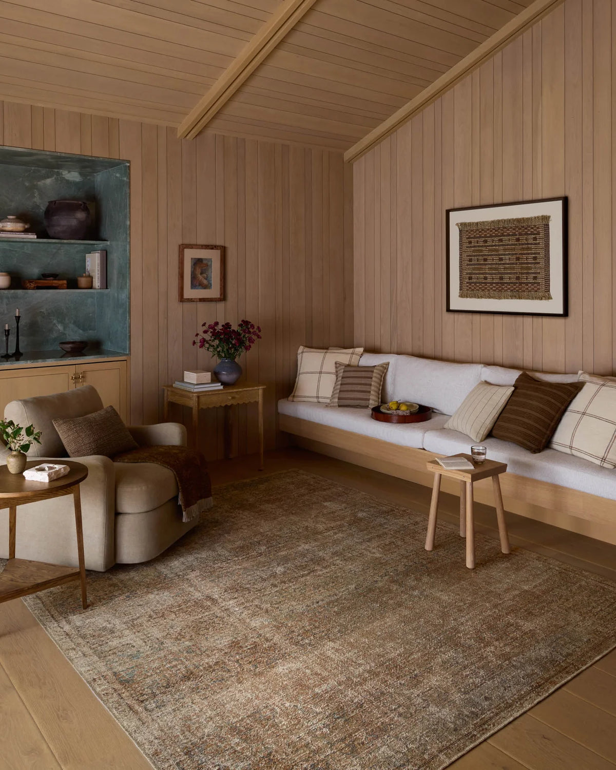 Cambria Ocean and Brick area rug styled beneath a linen sofa with natural wood furniture and layered textiles in an organic modern living room.