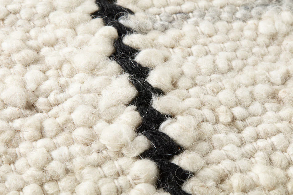 Close-up of the handwoven wool, polyester, and cotton blend with rich texture on the Amber Lewis Carla pillow.