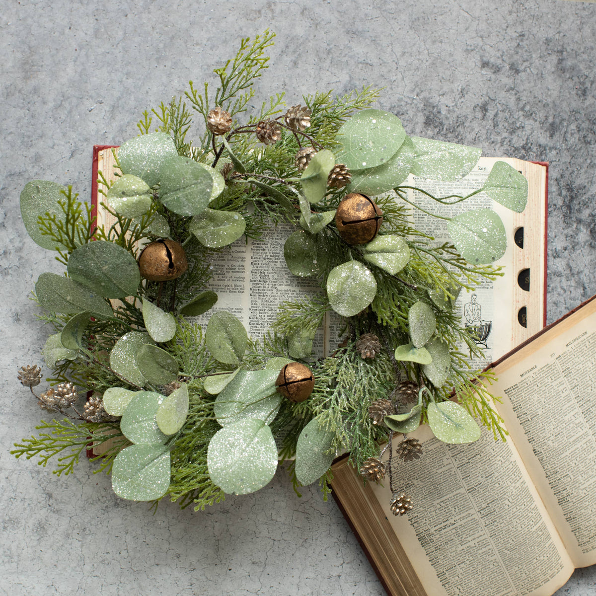 14-inch Christmas candle ring with cedar, eucalyptus, pinecones, frosted greenery, and antique-style jingle bells.
