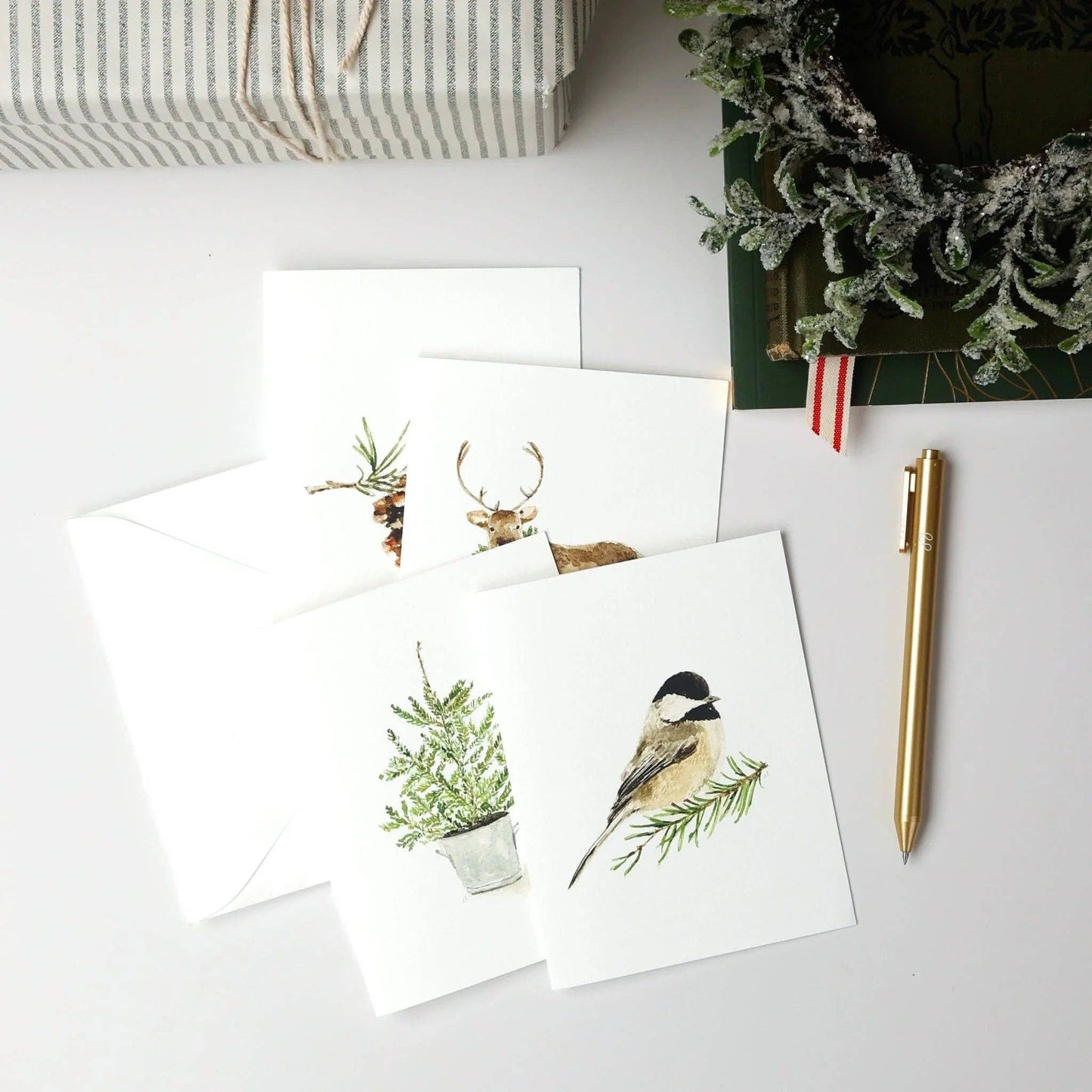 Assorted Christmas watercolor notecards printed on premium 120 lb superfine paper with blank interiors for personalized holiday messages.