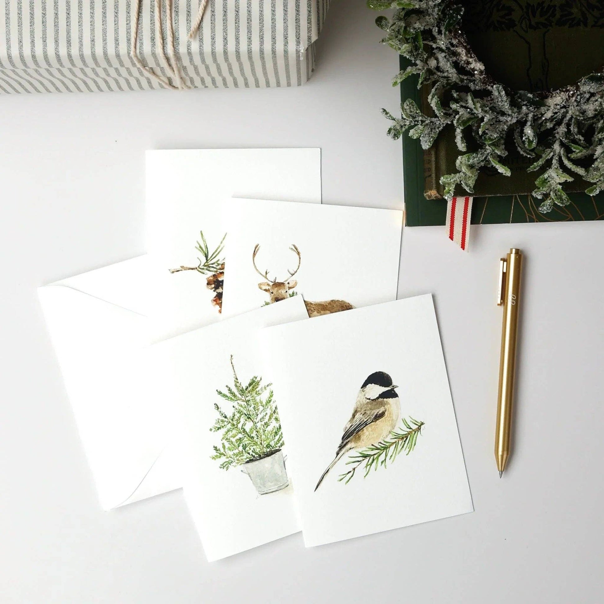 Assorted Christmas watercolor notecards printed on premium 120 lb superfine paper with blank interiors for personalized holiday messages.