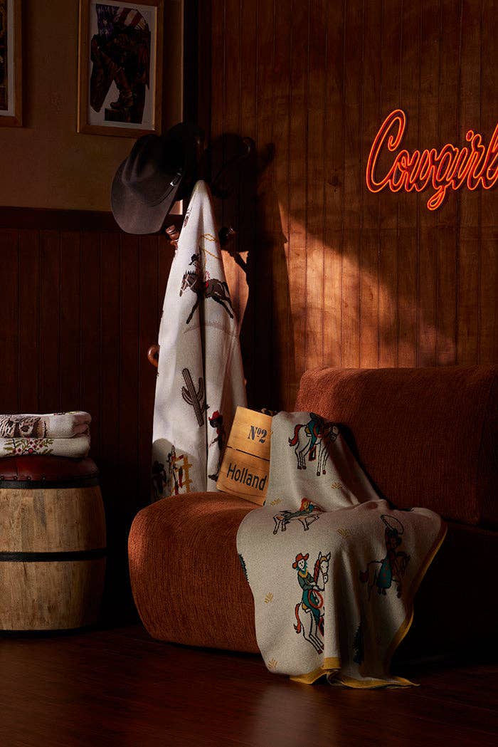 Wild West Legends throw blanket layered across the foot of a bed, adding timeless Western character and warmth to a thoughtfully curated home.