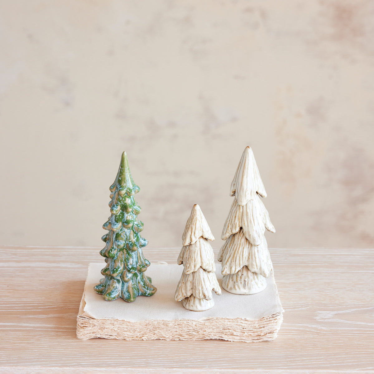 Cream reactive glaze stoneware Christmas trees in small and large sizes with naturally varied ceramic finishes.