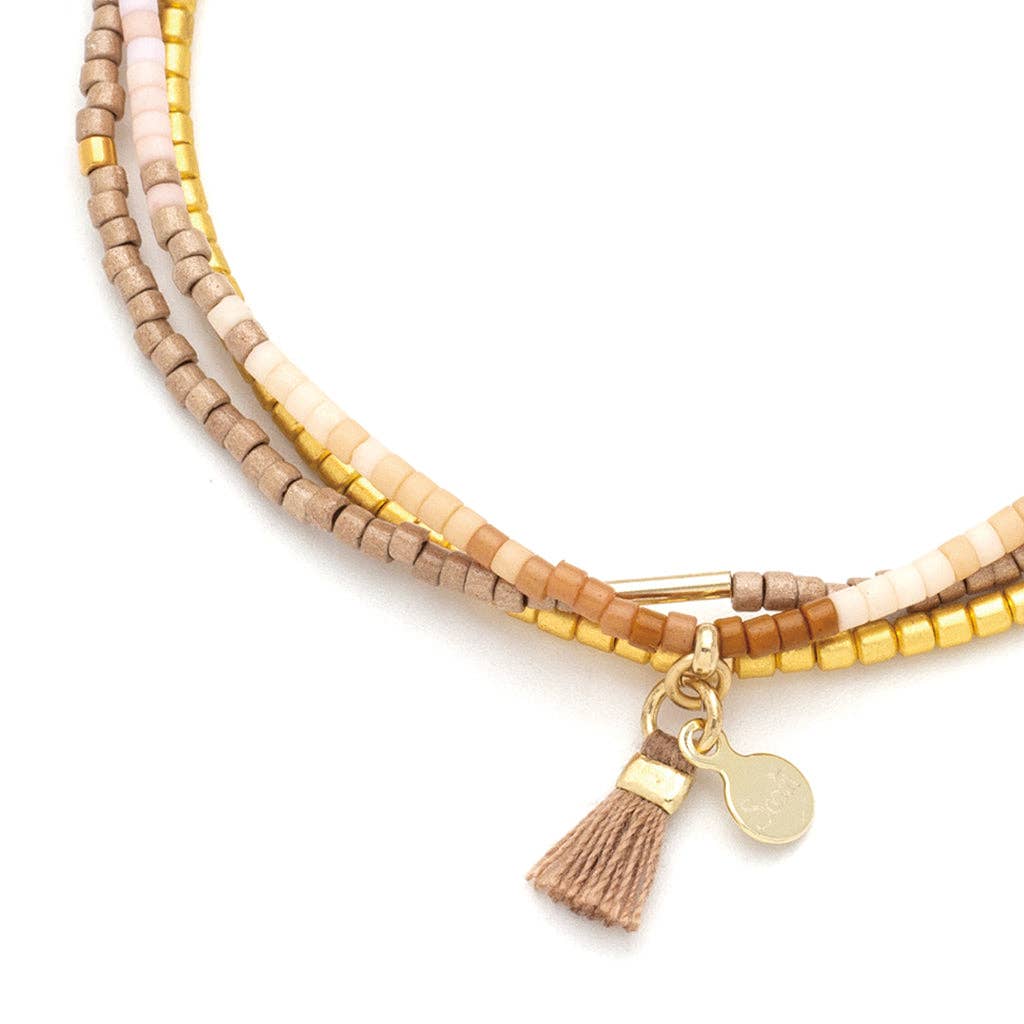 Close-up of Desert Multi Miyuki Delica beads, gold accents, and Scout signature tassel on the Chromacolor Bracelet Trio.